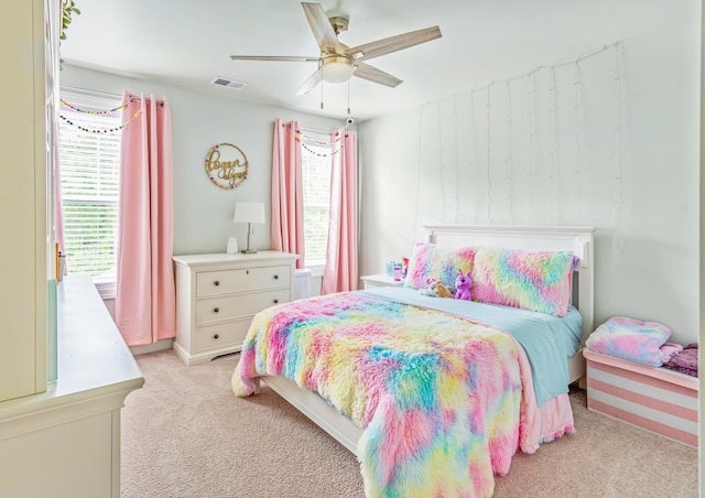 carpeted bedroom featuring multiple windows and ceiling fan