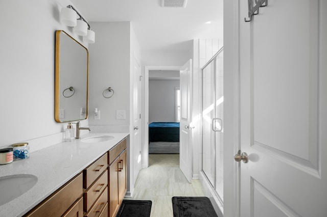 bathroom with vanity and a shower with shower door