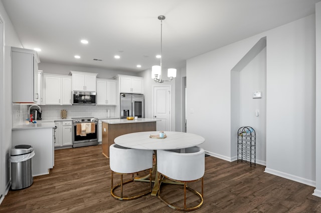 dining area featuring sink, dark hardwood / wood-style floors, and a notable chandelier