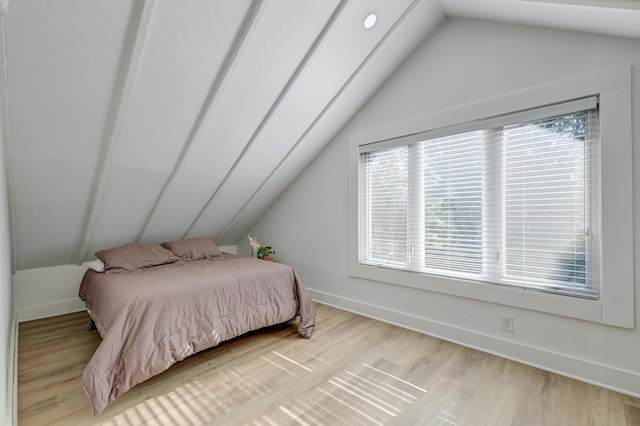 bedroom with light hardwood / wood-style floors and lofted ceiling