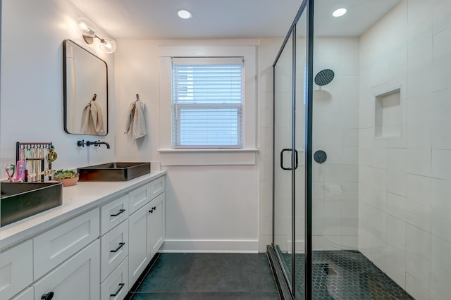 bathroom featuring a shower with door and vanity