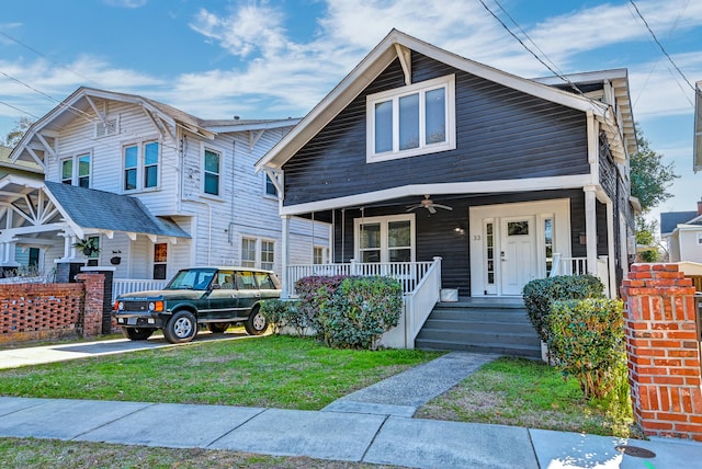 view of front of property with a front yard, ceiling fan, and a porch