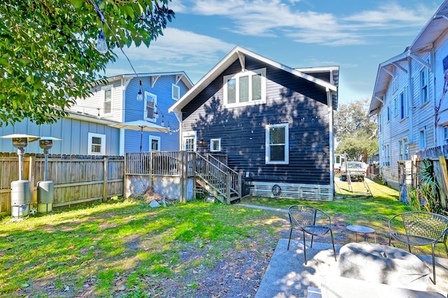 back of property with a patio area and a lawn