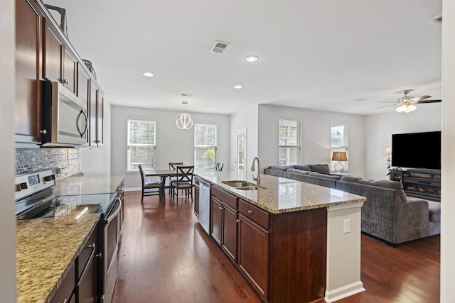 kitchen featuring stainless steel appliances, dark wood-type flooring, a sink, and visible vents