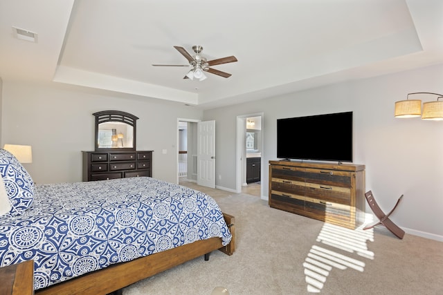 carpeted bedroom featuring ceiling fan, a raised ceiling, visible vents, and baseboards