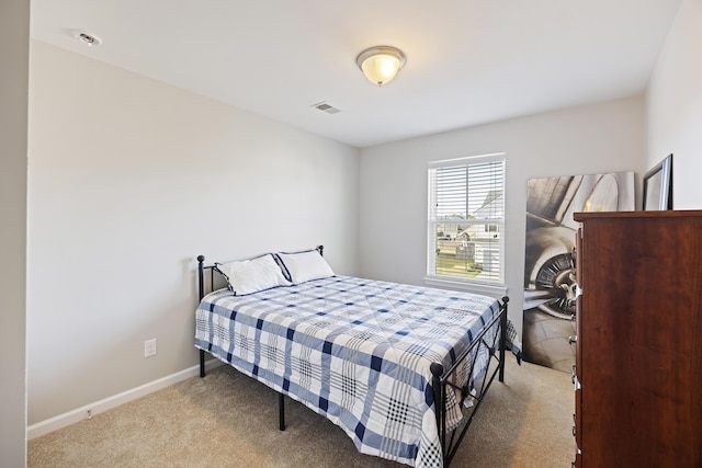 bedroom with carpet floors, visible vents, and baseboards