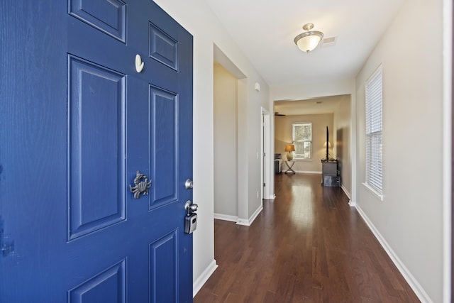 interior space with baseboards, visible vents, and dark wood finished floors