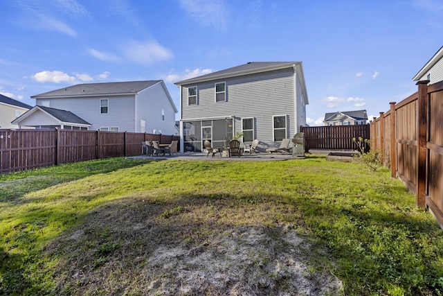 rear view of house featuring a lawn, a patio area, and a fenced backyard