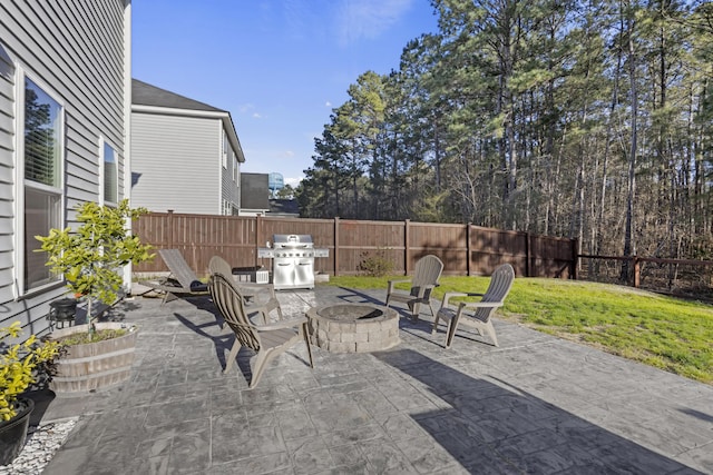 view of patio featuring an outdoor fire pit, a grill, and fence