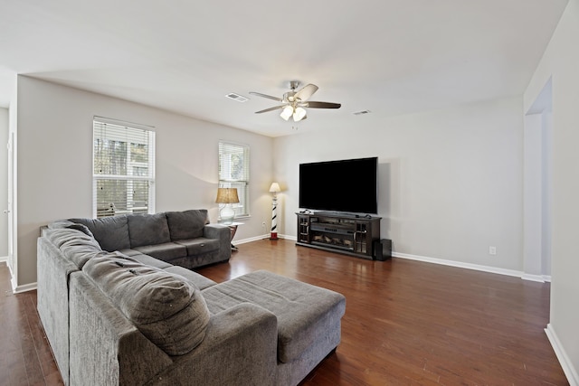 living area featuring dark wood-style floors, visible vents, and baseboards