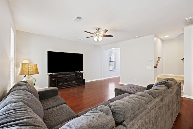 living area with a healthy amount of sunlight, baseboards, visible vents, and dark wood finished floors