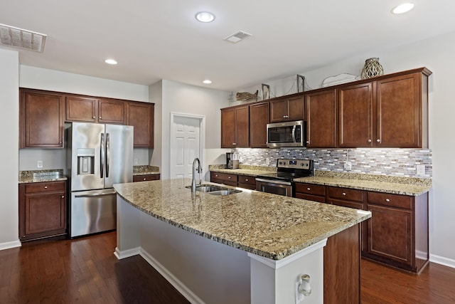 kitchen with appliances with stainless steel finishes, dark wood-style flooring, a sink, and visible vents