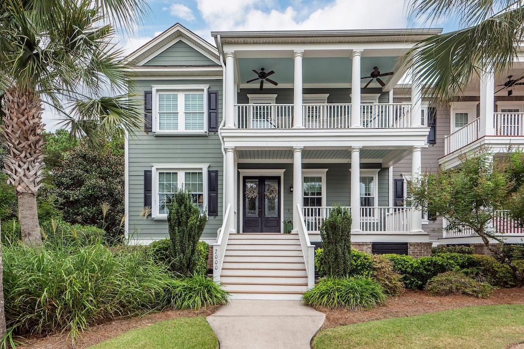 view of front of property with ceiling fan, a balcony, and covered porch