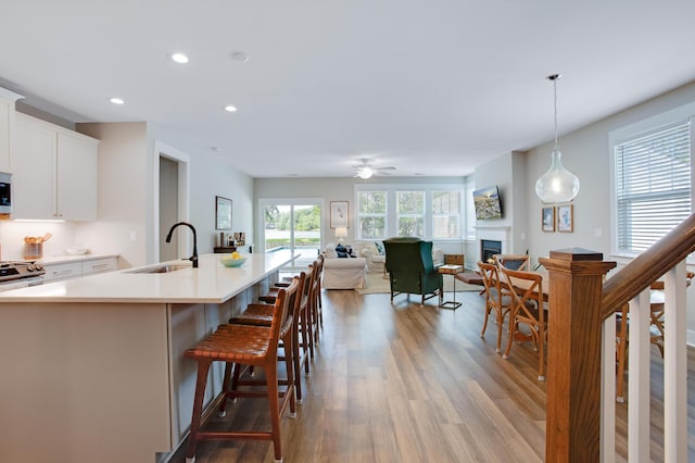 1607 Waterside Blvd, Moncks Corner, SC 29461 - kitchen with a sink, light wood finished floors, recessed lighting, white cabinets, and a fireplace
