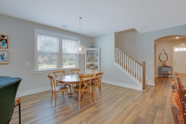 1607 Waterside Blvd, Moncks Corner, SC 29461 - dining space featuring arched walkways, plenty of natural light, light wood-type flooring, and stairway