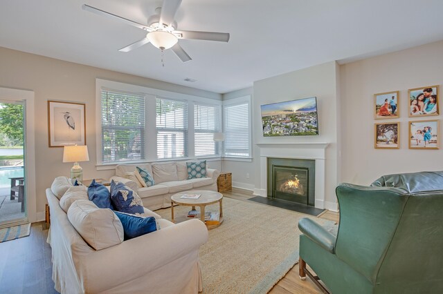 1607 Waterside Blvd, Moncks Corner, SC 29461 - living room with wood finished floors, a ceiling fan, a fireplace with flush hearth, and baseboards