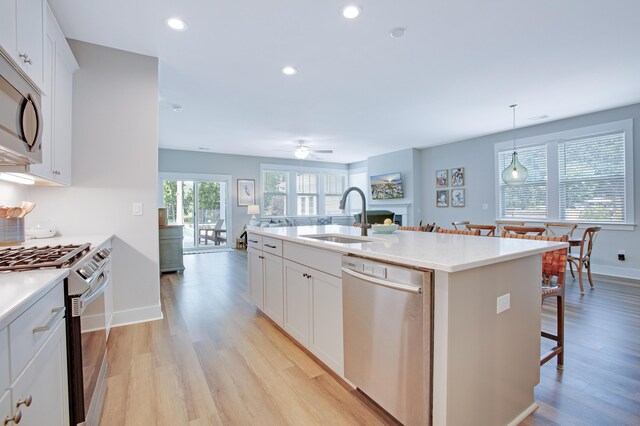 1607 Waterside Blvd, Moncks Corner, SC 29461 - kitchen with stainless steel appliances, a sink, light wood-style floors, a center island with sink, and light countertops