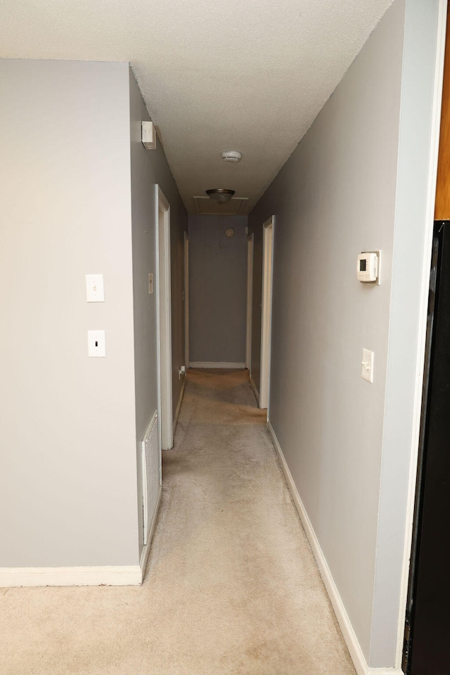 corridor featuring light colored carpet