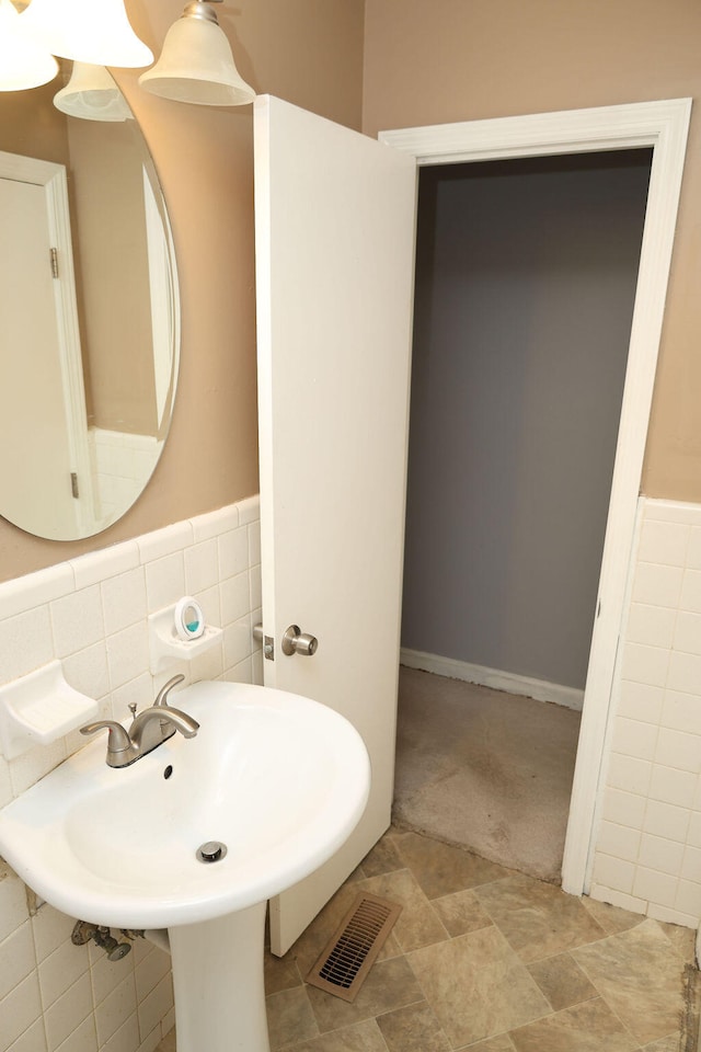 bathroom with tile walls and sink