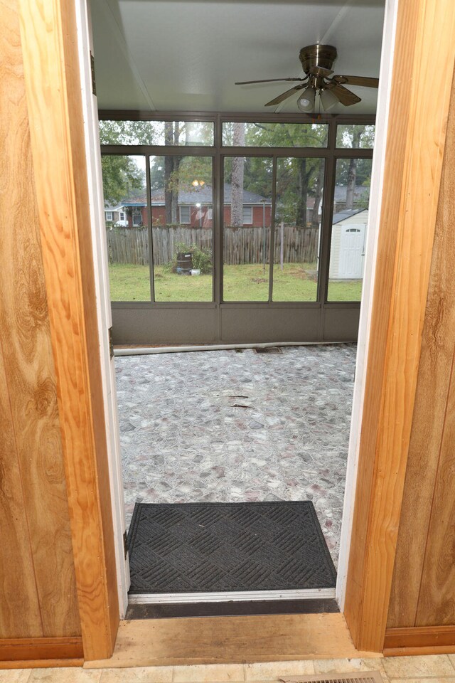 unfurnished sunroom featuring ceiling fan