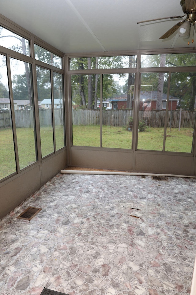 unfurnished sunroom featuring plenty of natural light and ceiling fan