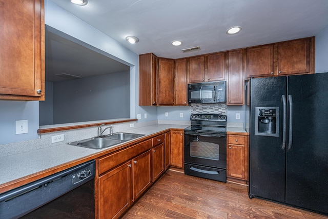 kitchen featuring dark hardwood / wood-style floors, sink, and black appliances