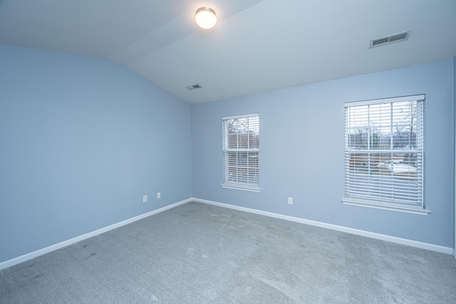 carpeted empty room with lofted ceiling