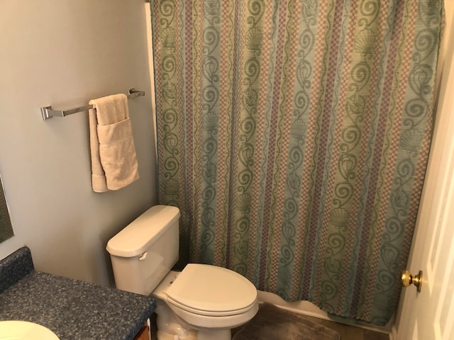 bathroom featuring curtained shower, vanity, and toilet