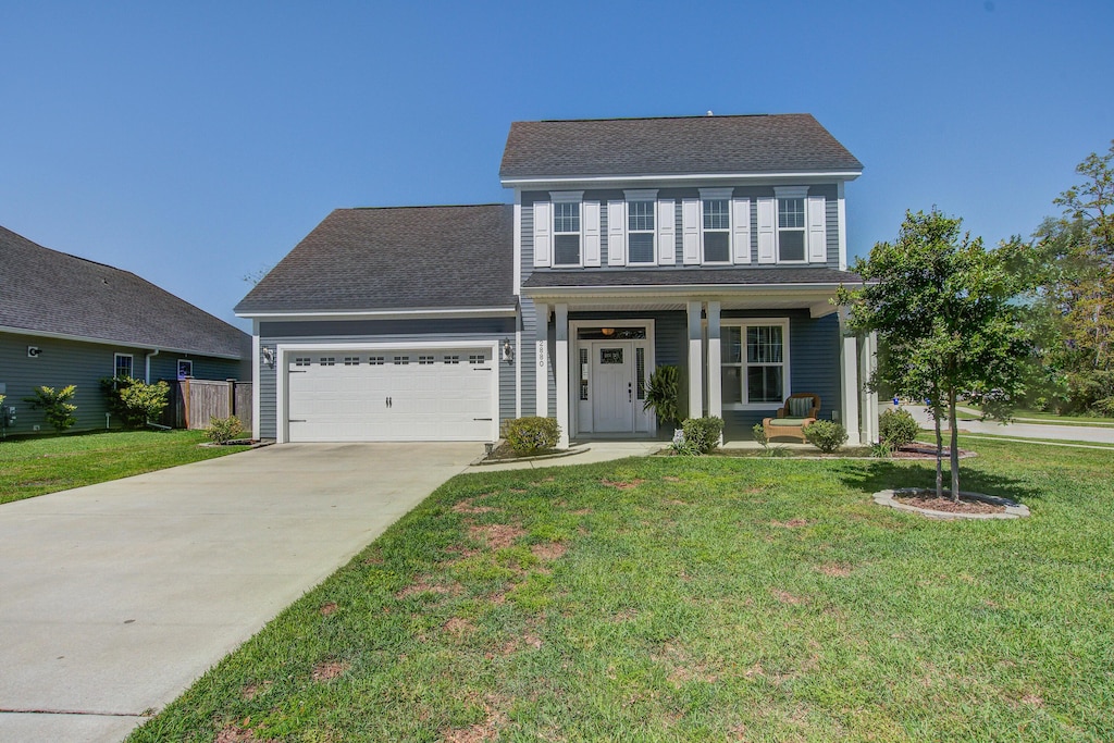 2880 Cavalcade Cir, Johns Island, SC 29455 - traditional home featuring covered porch, a front lawn, an attached garage, a shingled roof, and concrete driveway