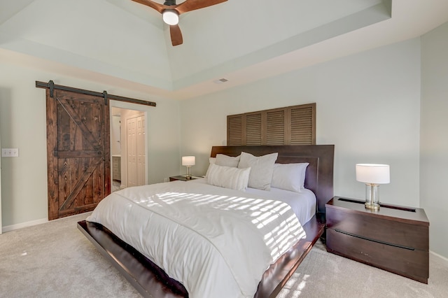 bedroom featuring ceiling fan, a barn door, light colored carpet, vaulted ceiling, and a closet