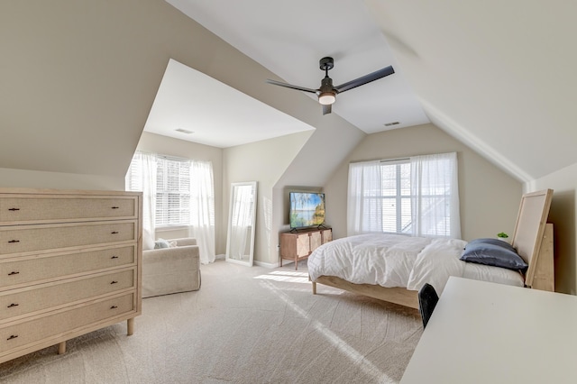 carpeted bedroom with multiple windows, ceiling fan, and lofted ceiling