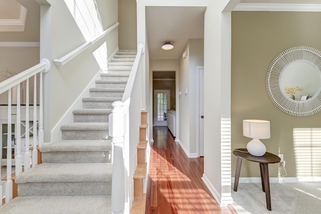 stairway featuring hardwood / wood-style flooring and ornamental molding