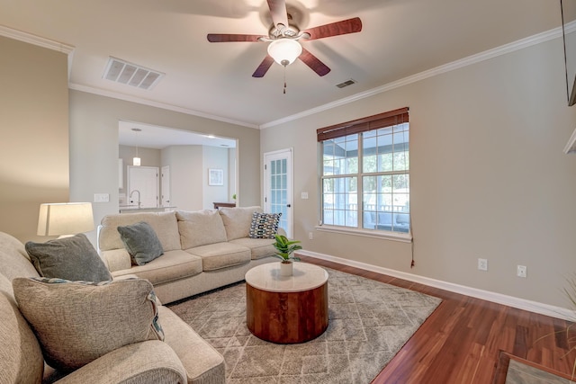 living room with wood-type flooring, ceiling fan, and ornamental molding