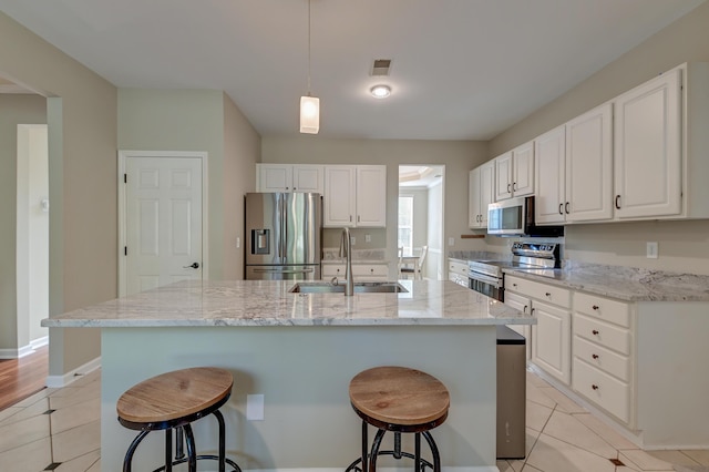 kitchen with a center island with sink, white cabinetry, sink, and appliances with stainless steel finishes