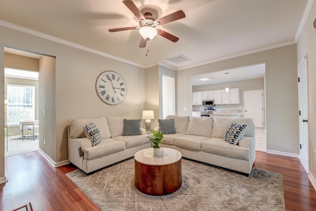 living room featuring ceiling fan, light hardwood / wood-style flooring, sink, and ornamental molding