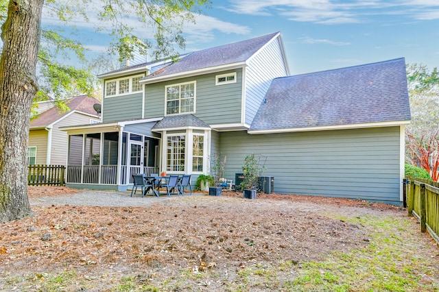 back of property with a sunroom and a patio area