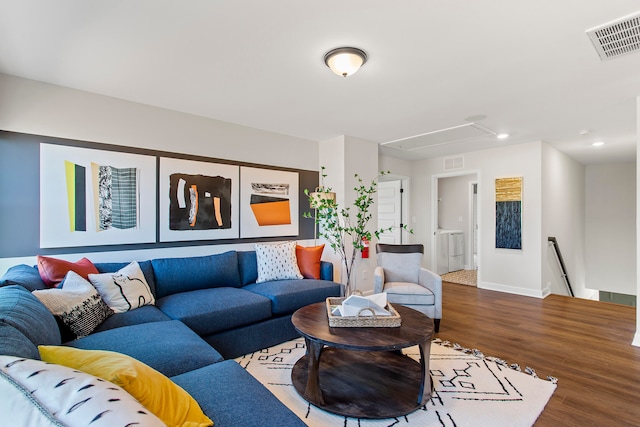 living room featuring wood-type flooring and washer / dryer