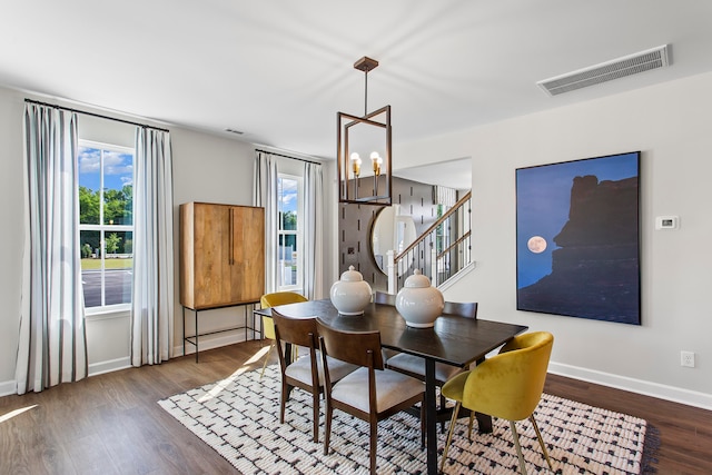 dining space with a notable chandelier, plenty of natural light, and dark hardwood / wood-style floors