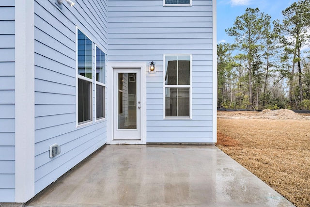 view of exterior entry with a patio area