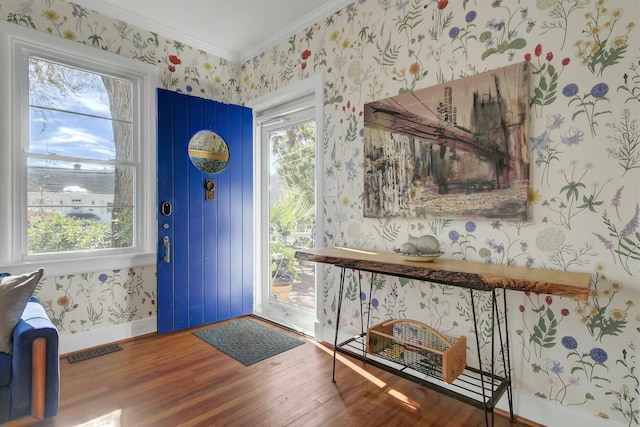 foyer with hardwood / wood-style floors and crown molding