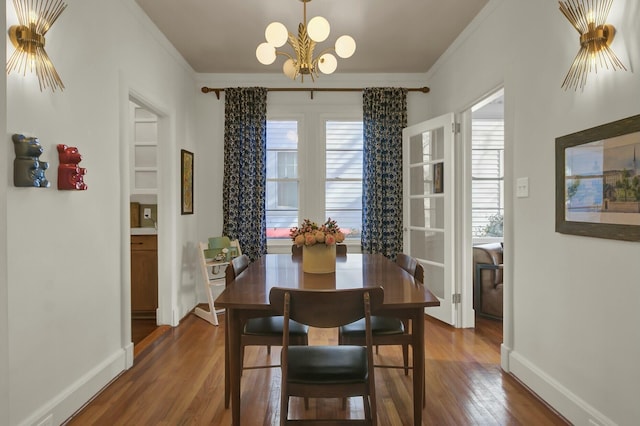 dining space featuring crown molding, a healthy amount of sunlight, a notable chandelier, and dark hardwood / wood-style flooring