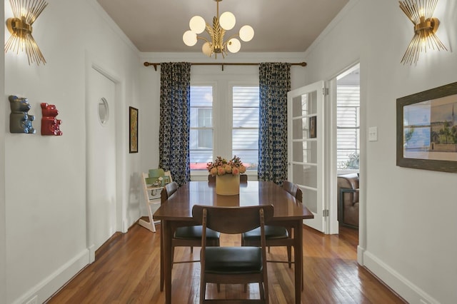 dining room featuring crown molding, an inviting chandelier, and dark hardwood / wood-style flooring