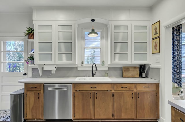 kitchen with stainless steel dishwasher, sink, and hanging light fixtures