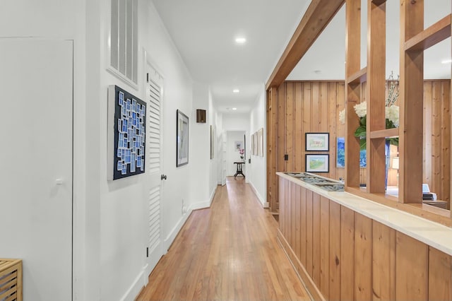 hall featuring wooden walls and light hardwood / wood-style flooring