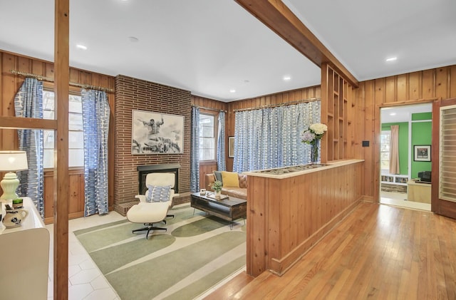 interior space featuring wooden walls, a fireplace, and a wealth of natural light