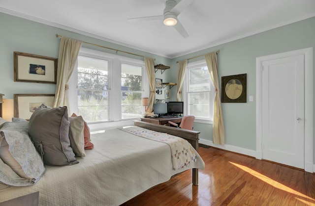 bedroom featuring hardwood / wood-style flooring, ornamental molding, and ceiling fan