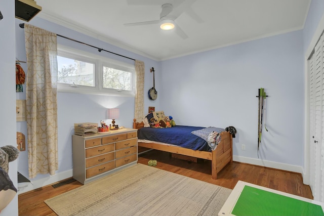 bedroom featuring crown molding, hardwood / wood-style floors, ceiling fan, and a closet