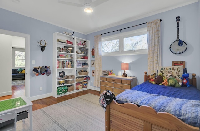 bedroom with ceiling fan, hardwood / wood-style floors, and multiple windows