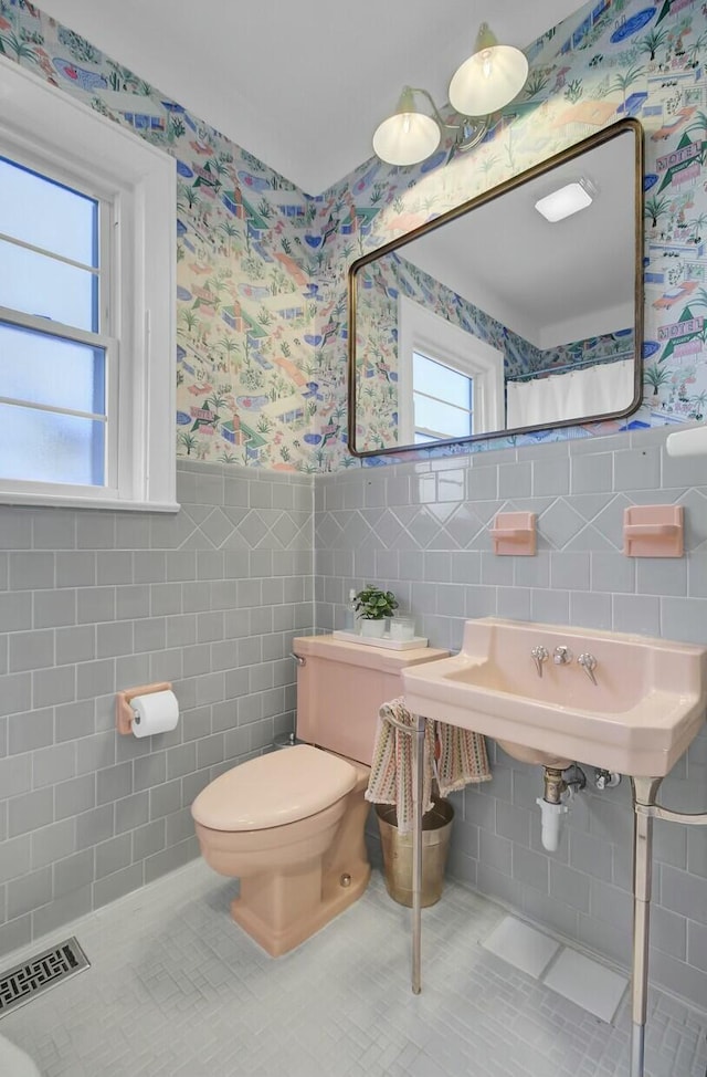 bathroom featuring tile walls, tile patterned floors, and toilet