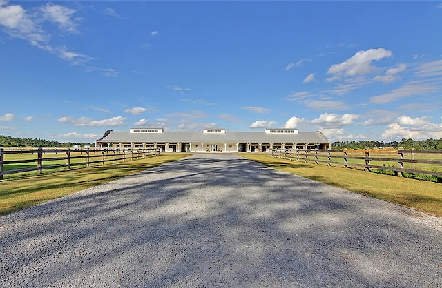 exterior space with driveway, fence, and a rural view